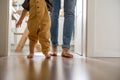 ÃÂ Little baby boy learning to walk with his father beside him Royalty Free Stock Photo